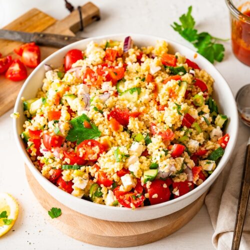 Bulgur Salad with Feta Cheese, bell pepper, tomatoes, and cucumber in a white bowl.