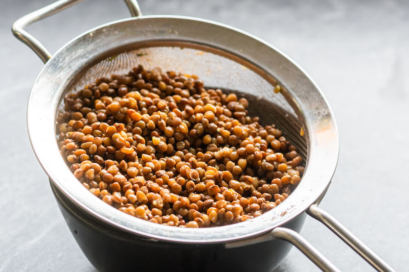 Canned lentils in a strainer.