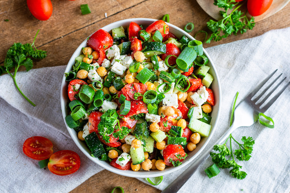 Overhead image of a healthy chickpea salad with canned chickpeas, tomatoes, feta cheese and cucumber.