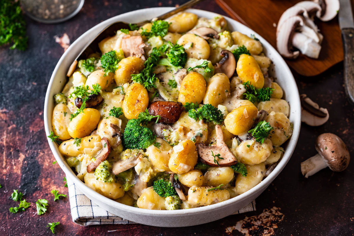 Pan-fried gnocchi with broccoli and mushrooms in a creamy sauce and decorated with fresh parsley.