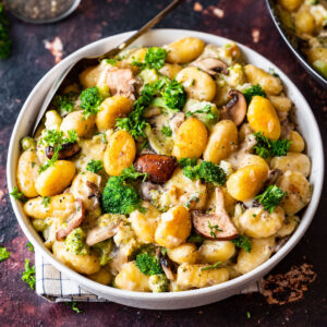 Pan-fried gnocchi with broccoli and mushrooms in a creamy sauce and decorated with fresh parsley.