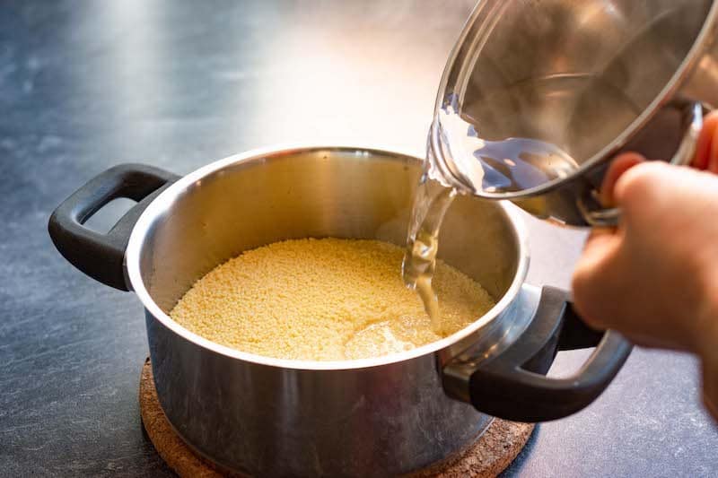 Preparing couscous by pouring boiling water over it.