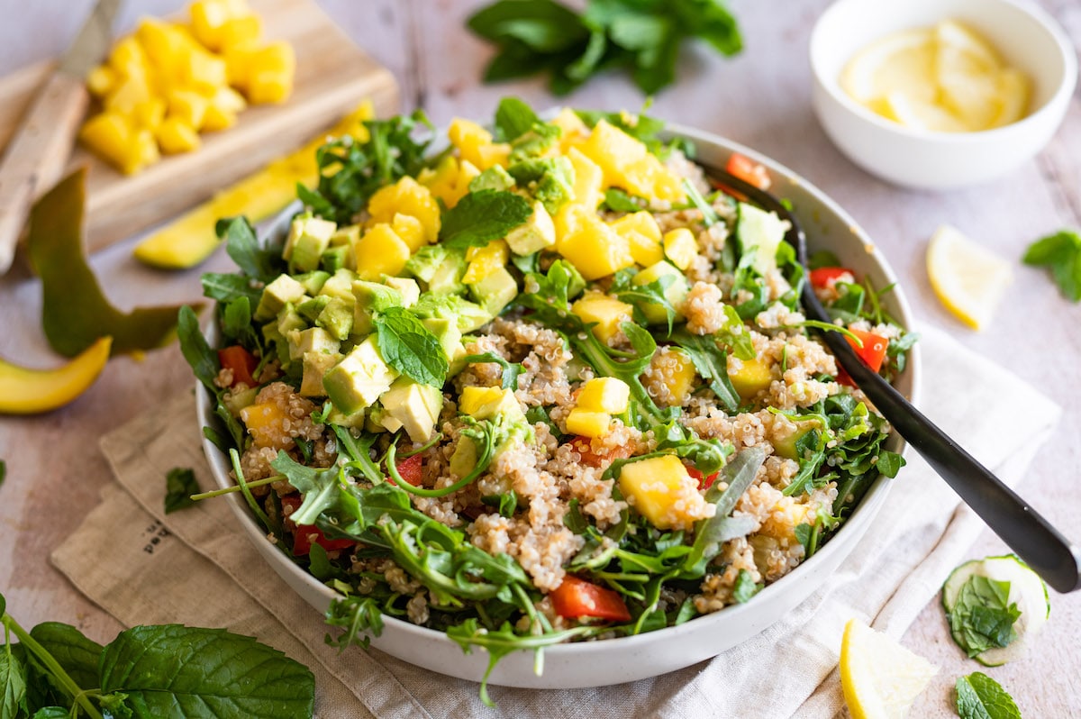 Quinoa Salad with avocado, mango and arugula in a bowl.