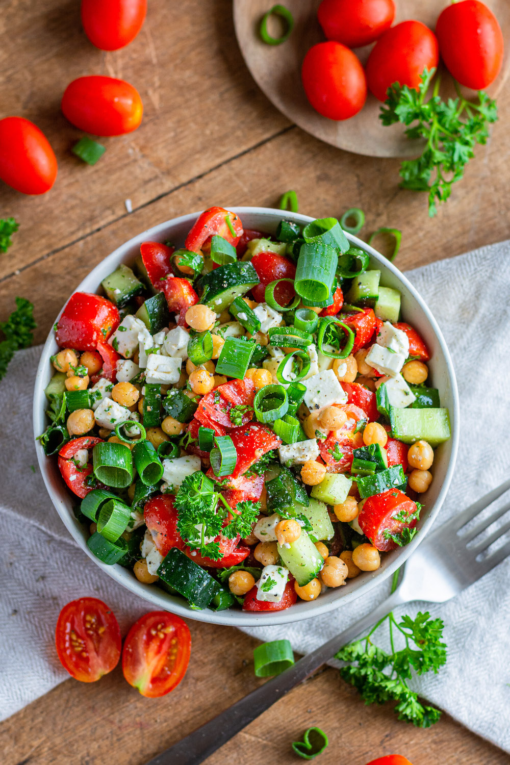 Simple chickpea salad recipe with feta cheese, cucumber, tomatoes, green onions and parsley.