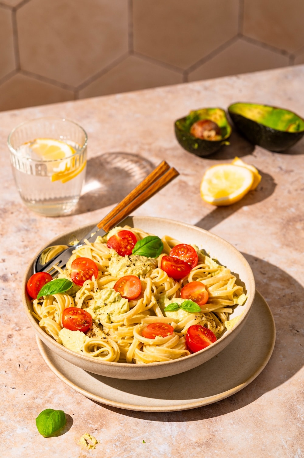 Pasta with cream avocado sauce and tomatoes.