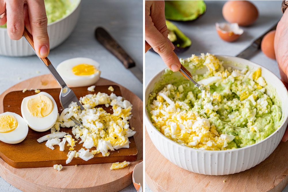Hard-boiled eggs are being mashed with a fork and then mixed with the avocados and greek yogurt.