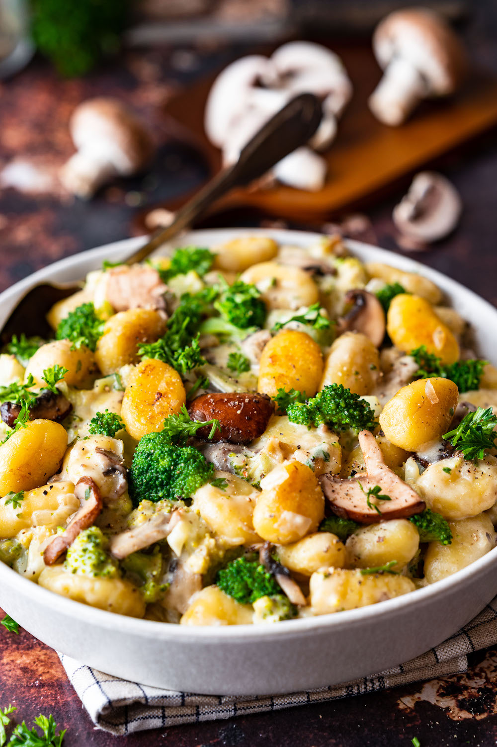 Gnocchi stir fry with broccoli and mushrooms in a white bowl.