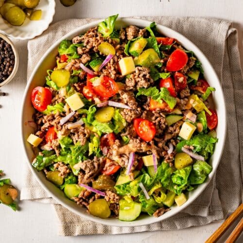 Healthy big mac salad with yogurt dressing served in a bowl.