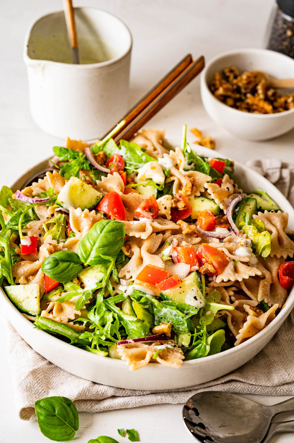 Healthy wholegrain pasta salad with arugula, bell pepper, cucumber, cherry tomatoes, and mozzarella cheese.
