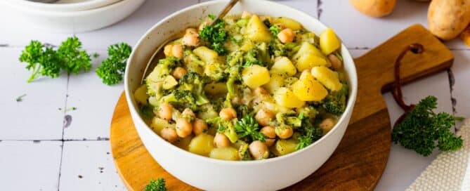 Potato broccoli curry with chickpeas and coconut milk served in a bowl.